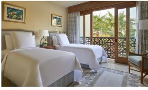 a hotel room with two beds and a balcony at Elegant Apartment in a Luxury Resort in Sharm El Sheikh