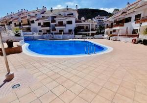 a large swimming pool in front of some buildings at Mar Holiday Home in Los Cristianos
