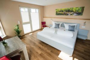 1 dormitorio con cama blanca y mesa en Burgers Hotel en Kippenheim
