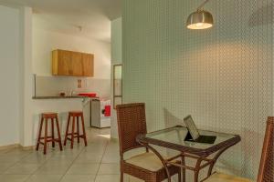 a kitchen with a glass table and chairs and a counter at Pousada Lua e Mar in Ilhéus