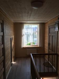 an empty room with a window and a staircase at Krūmiņmāja in Staicele