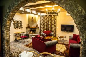 a living room with two couches and a fireplace at Vila Eden Boutique Hotel in Korçë