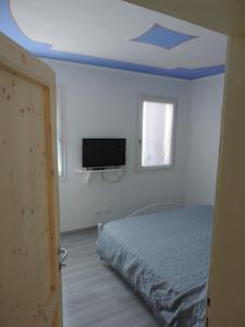 a bedroom with a bed and a flat screen tv at Casa Rossa in Pianzano