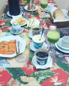 a table with plates of food and drinks on it at Pousada Gardenia Guest House in Gramado