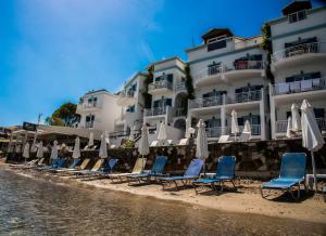 チィリヴィにあるFiloxenia Beachのホテルの隣のビーチにある椅子とパラソルのグループ