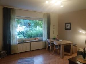 ein Wohnzimmer mit einem Tisch und einem Fenster in der Unterkunft Ferienwohnung Falke in Schmallenberg