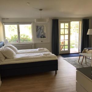 a bedroom with a large bed and two windows at Trouville Bed & Breakfast in Hornbæk