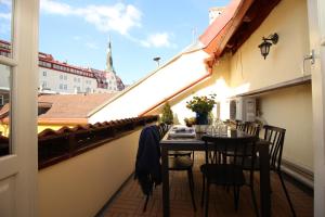 balcón con mesa, sillas y vistas a la ciudad en Tallinn City Apartments Luxury 4 bedroom with terrace and sauna en Tallin