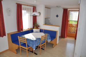 ein Esszimmer mit einem blauen Tisch und Stühlen in der Unterkunft Appartements Wiesenheim in Oberrasen