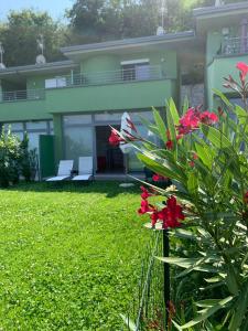 uma casa com um jardim com flores vermelhas em frente em Un Balcone sul Garda em Tremosine Sul Garda