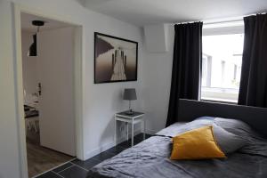 1 dormitorio con cama con almohada amarilla y ventana en City Appartment Krefeld - 20 km DUS Airport/Messe, en Krefeld