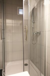 baño con ducha y puerta de cristal en City Appartment Krefeld - 20 km DUS Airport/Messe, en Krefeld