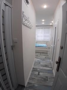 a hallway with a bed in a room with white walls at WHITE APARTMENT, Kraskova 2, BRATISLAVA in Bratislava