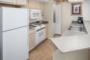 a kitchen with a stove, refrigerator, sink and dishwasher at The Suites at Fall Creek in Branson