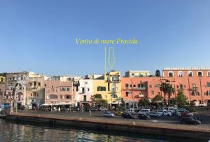 a city with cars parked next to a river at Vento di mare in Procida