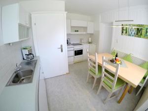 una cucina con tavolo, sedie e lavandino di Melanie's Appartement a Westendorf