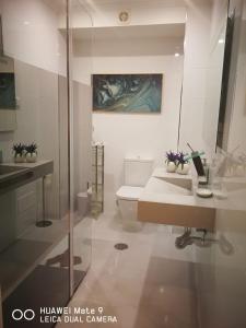 a bathroom with a sink and a toilet and a painting at Atlântida T1 in Cavacos