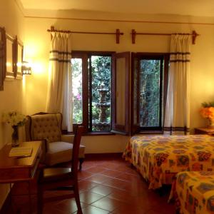 瓦哈卡德華雷斯的住宿－Hotel Maela，一间卧室配有一张床、一把椅子和窗户。