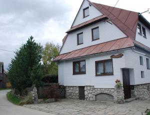 una gran casa blanca con techo rojo en Pokoje u Danusi, en Czarna Góra