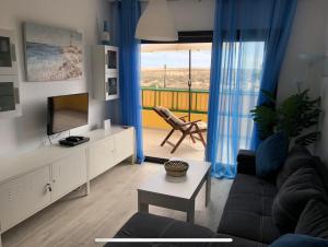 ein Wohnzimmer mit Sofa und Fernseher in der Unterkunft Dunasol in Corralejo