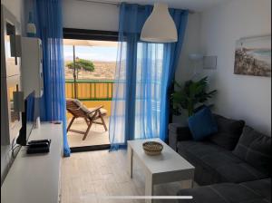 ein Wohnzimmer mit Sofa und Tisch in der Unterkunft Dunasol in Corralejo