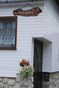 a door to a house with a sign on it at Pokoje u Danusi in Czarna Góra