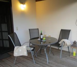 a table and chairs with wine bottles and glasses on it at Haus Ilse in Waren