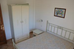 1 dormitorio con 1 cama, armario y armario en Li Seddi Country House, en Badesi