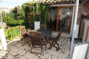 a patio with a table and chairs on a patio at Gîte aux Berges du Canal in Capestang