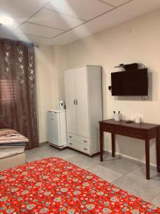 a living room with a television and a table and a room at Ashel Hotel in Beer Sheva