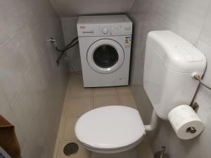 a bathroom with a toilet and a washing machine at La Casa del Campanile in Summonte