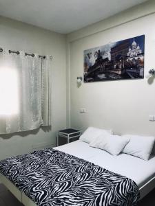 a bedroom with a bed with a zebra print blanket at Ashel Hotel in Beer Sheva