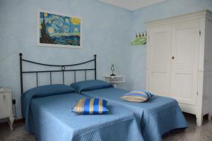 a bedroom with a blue bed with two pillows on it at Ciassa Noeva in Pieve di Teco