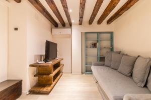 - un salon avec un canapé et une télévision dans l'établissement Ramo Delle Moschette, à Venise