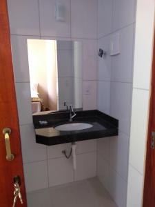 un baño con lavabo y espejo en Pousada Bontempo, en Pirenópolis