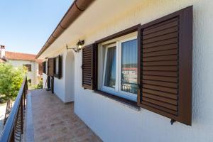 een balkon met een raam met houten luiken op een huis bij Lovely VILLA Piljan with a private swimming POOL in Bokordići