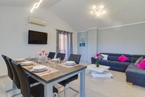 een woonkamer met een tafel en een blauwe bank bij Lovely VILLA Piljan with a private swimming POOL in Bokordići