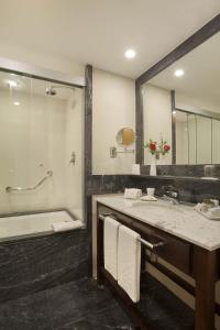 a bathroom with a tub and a sink and a mirror at Windsor Marapendi Hotel in Rio de Janeiro