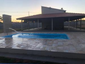 a swimming pool in front of a building at Cantinho do Folclore in Olímpia