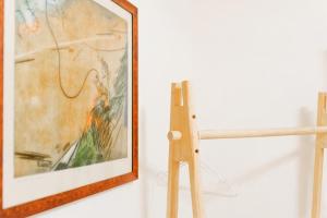 una pintura en una pared junto a un marco de madera en VILLA CENTRUM APARTMÁNY s RAŇAJKAMI A SAUNOU, en Martin