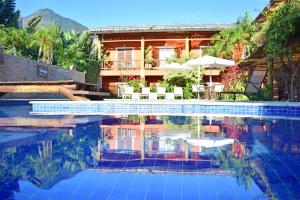 a swimming pool in front of a house at Bella Ilha Pousada in Ilhabela