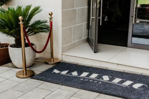 a welcome mat in front of a door with a red ribbon at Hotel Majestic in Budva