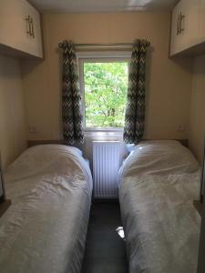 2 camas en una habitación pequeña con ventana en Norah, en Nunspeet