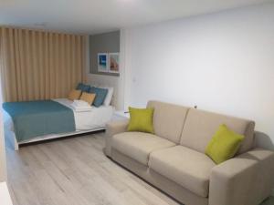 ein Wohnzimmer mit einem Sofa und einem Bett in der Unterkunft O Palacete in Vila Real