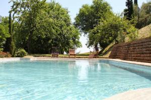 una piscina en un patio con 2 sillas en Villa Melagrana, en Fano