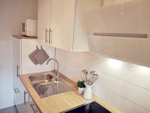 a kitchen with a sink and white cabinets at Baltrumweg 4 in Wangerland