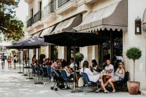 a group of people sitting at tables outside a restaurant at Hotel Majestic in Budva