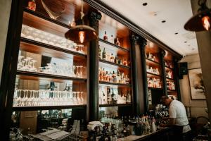 a man standing at a bar in a pub at Hotel Majestic in Budva