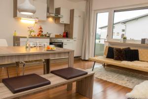 een keuken en een woonkamer met een tafel en een bank bij hoamelig in Batschuns