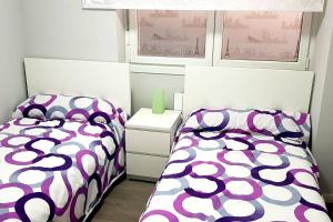 a bedroom with two beds and a window at LAIA HOME GARAJE Y WIFI in Barakaldo
